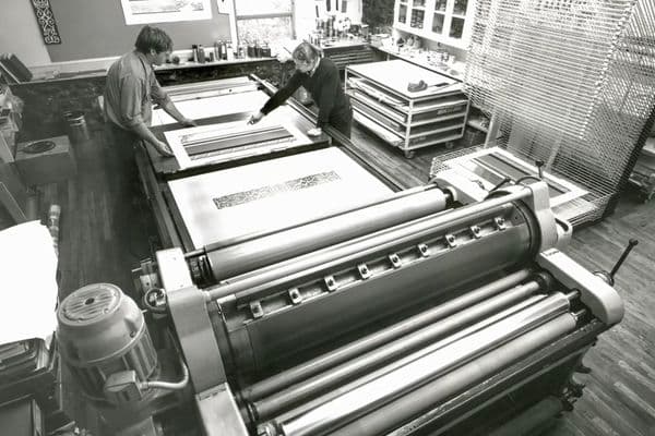 Video still of photograph showing old press machine.