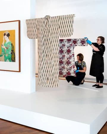 Photograph of kimonos being attended to by textile conservators.