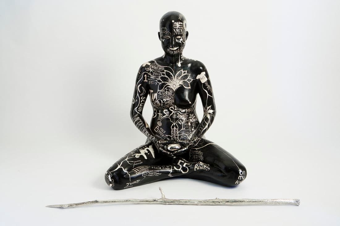 photo of a life-size sculpture of a female form sitting cross-legged