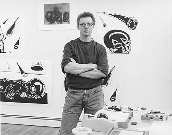 Black and white photograph of Per Inge Bjørlo in front of his works