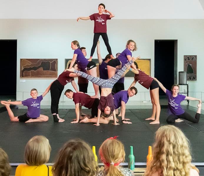 Audience of young people watching a dance troupe performing acrobatics