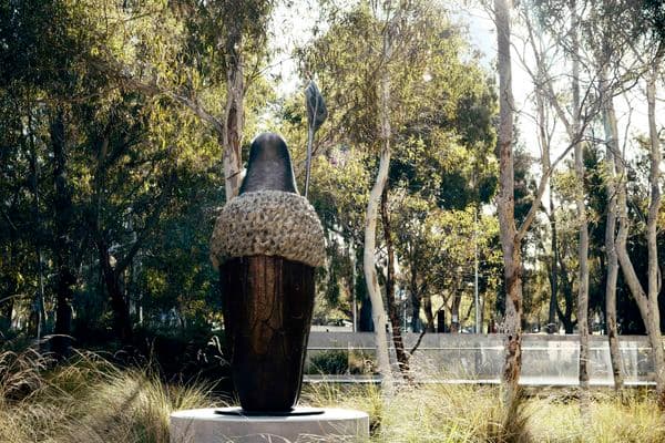 A bronze sculpture in a garden bed