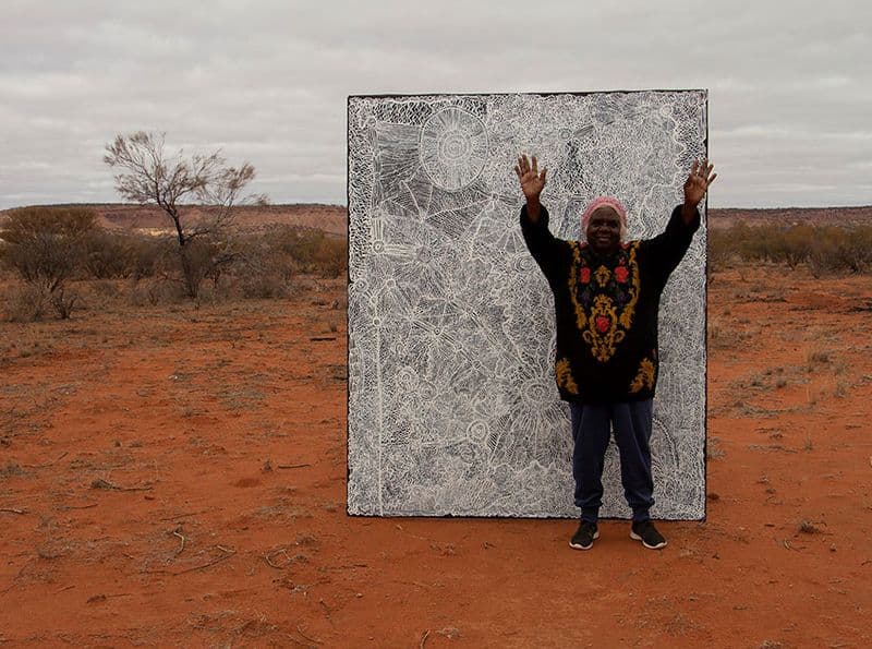 Betty Muffler stands in front of her artwork Ngangkari Ngura
