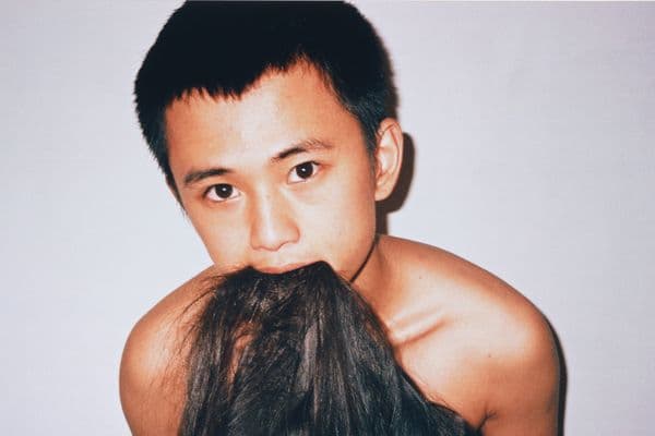 A photograph of a man with hair in his mouth