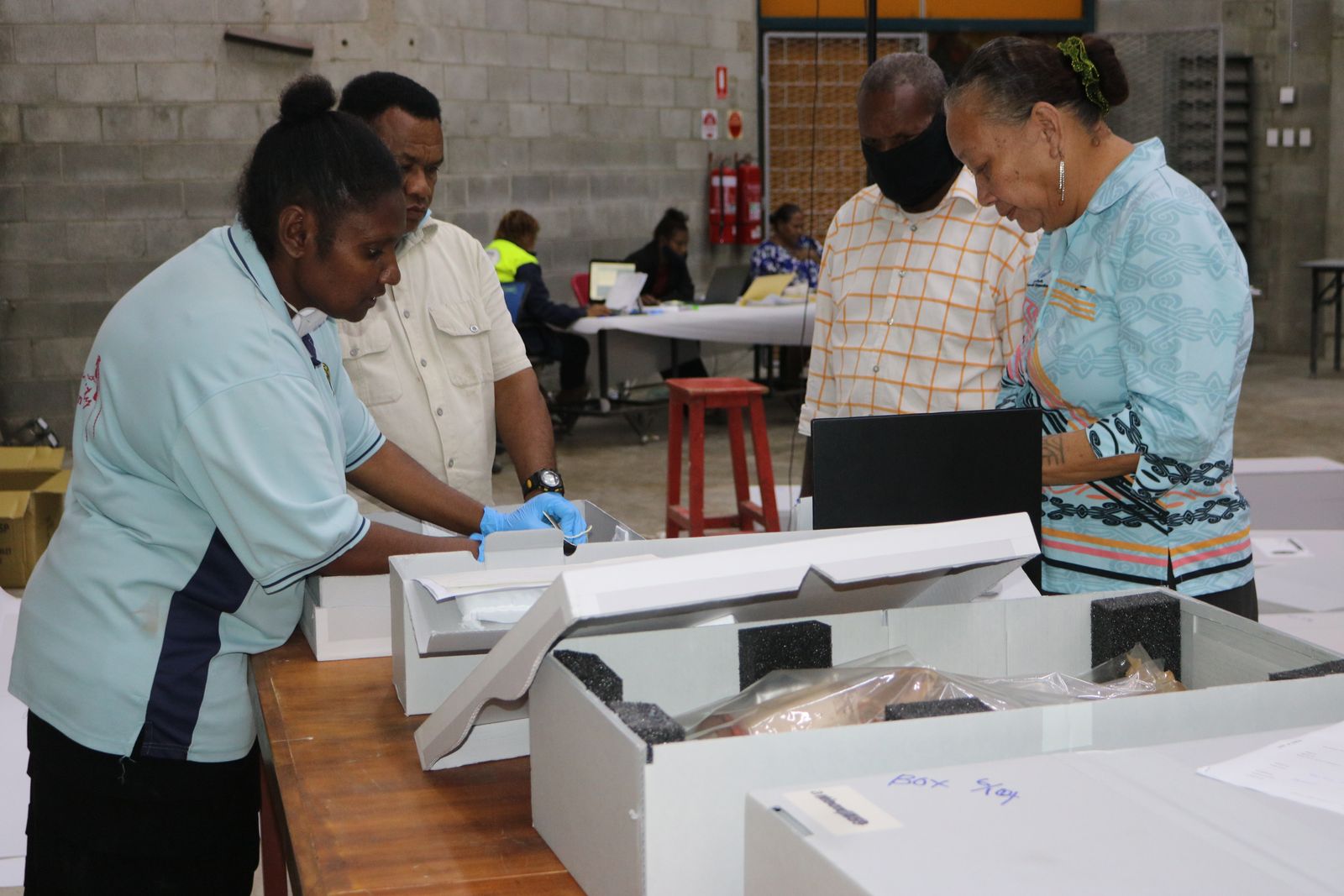 Senior Curator Grace Vele with NMAG staff cataloguing the objects into the NMAG collection.