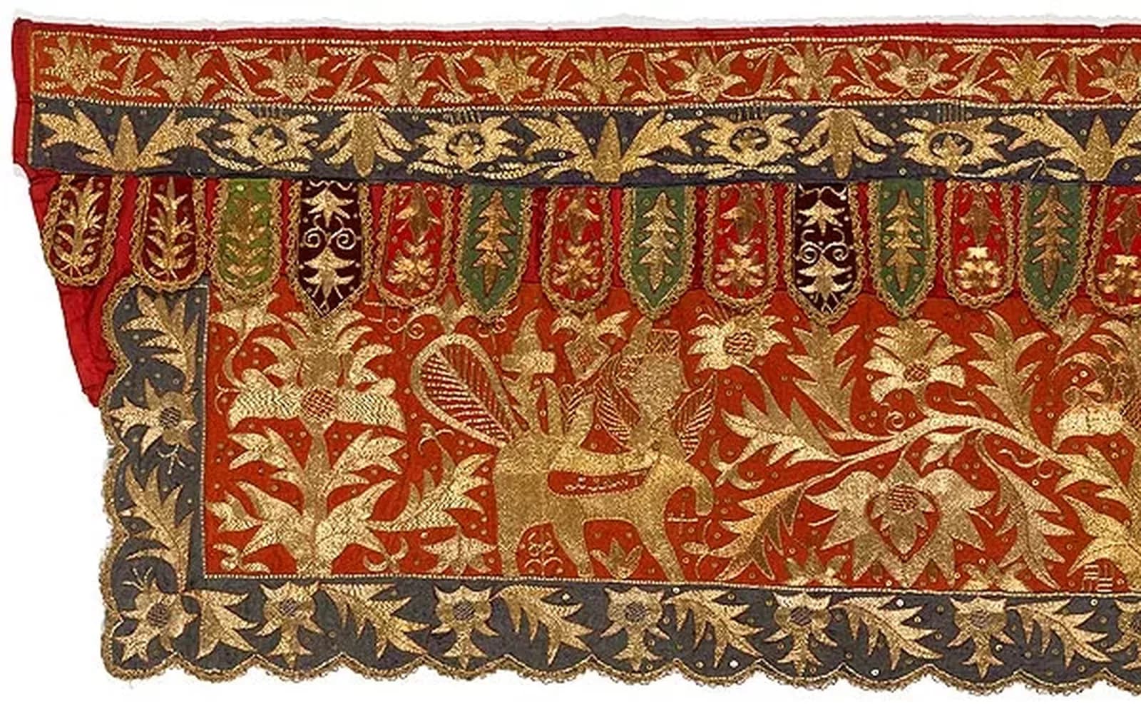 A red, green and blue tapestry richly embroidered with gold thread forming flowering trees and a pair of bouraq, a mythical winged animal