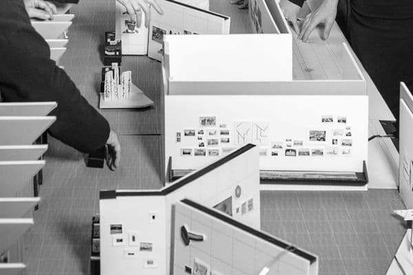 Model layout of exhibitions with hands adjusting the location of works of art