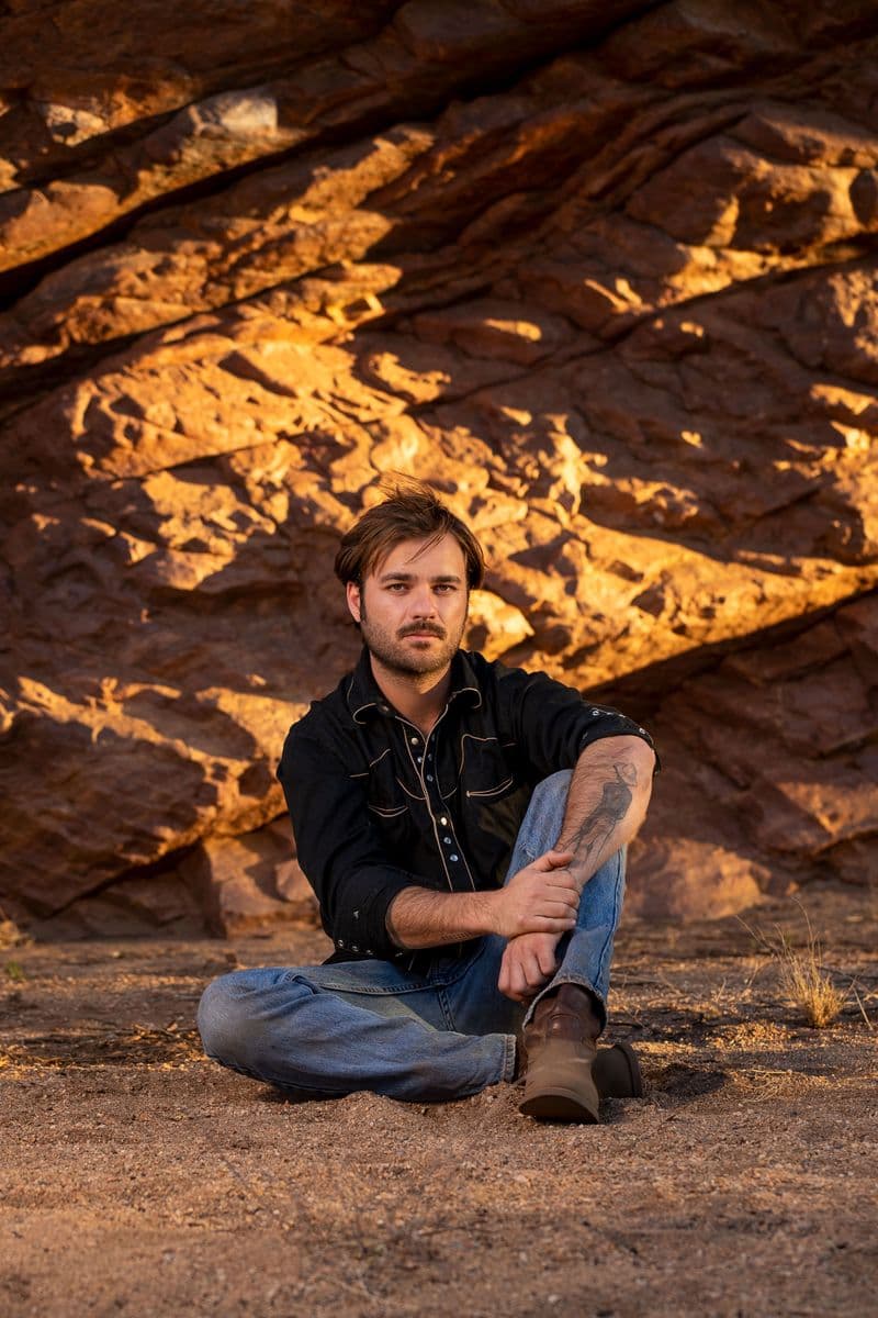 Portrait of Dylan River sitting down outside