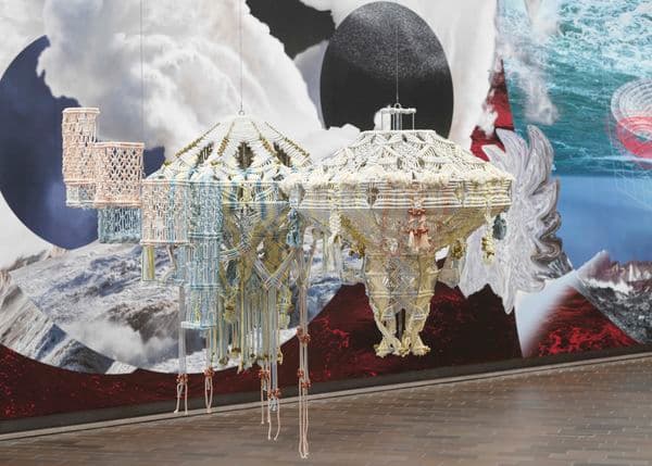 Three low hanging pastel coloured woven tapestries pictured against a dynamic wallpaper