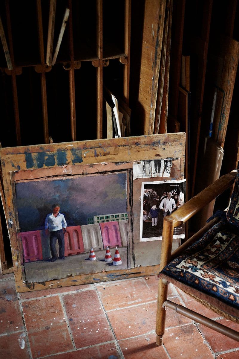A photograph of a painting of a man standing against a wall