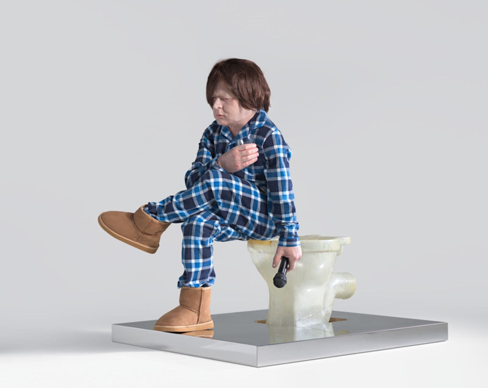 A sculpture of a ridiculously undersized man sitting on a transparent toilet in blue flannel pyjamas holding a glass of whiskey and a microphone