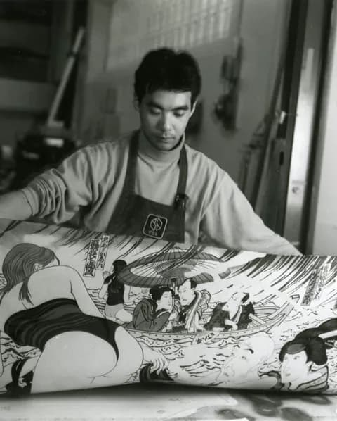 Yasuyuki Shibata removing newly printed impression of Masami Teraoka’s ‘Kunisada Eclipsed’ from ‘Hawaii Snorkel Series’ woodblock