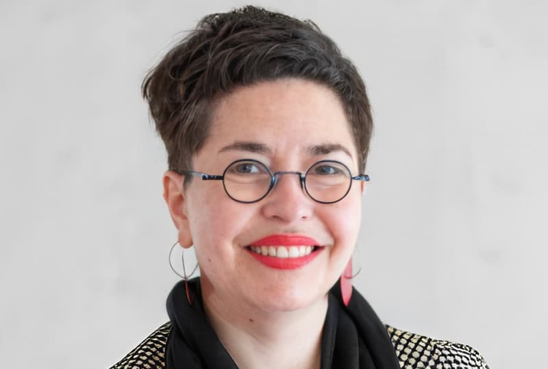 Portrait of a brunette woman with short hair with black glasses