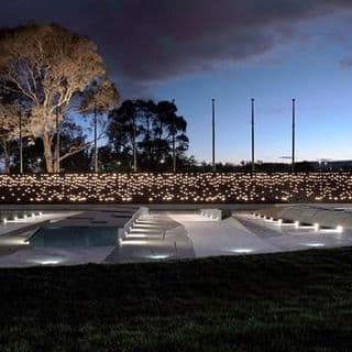 Photograph of memorial at night with small lights in distance