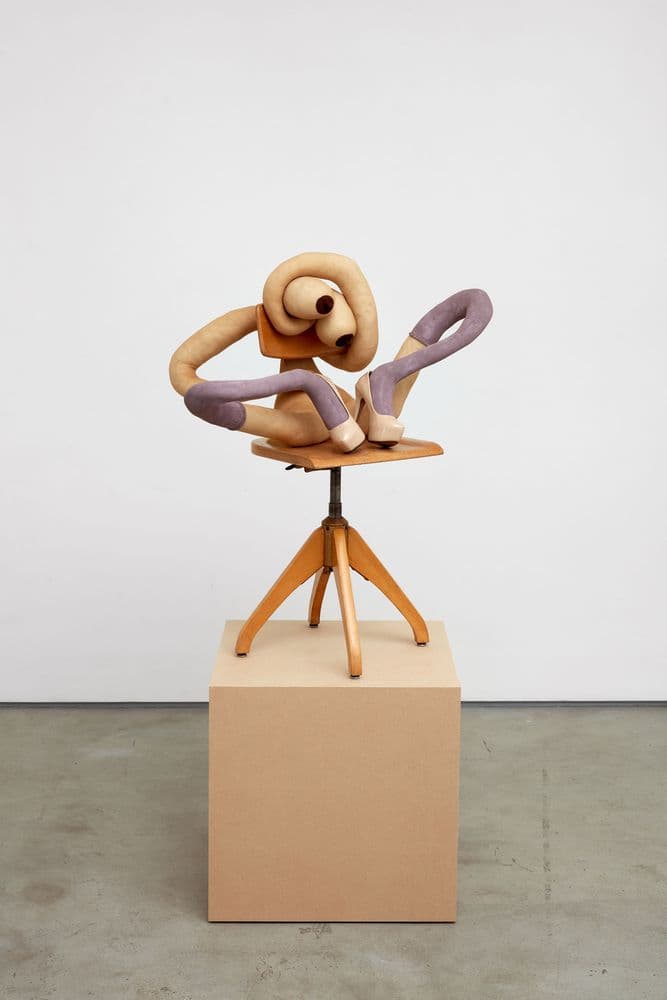 sculpture depicting abstract figure sitting on chair
