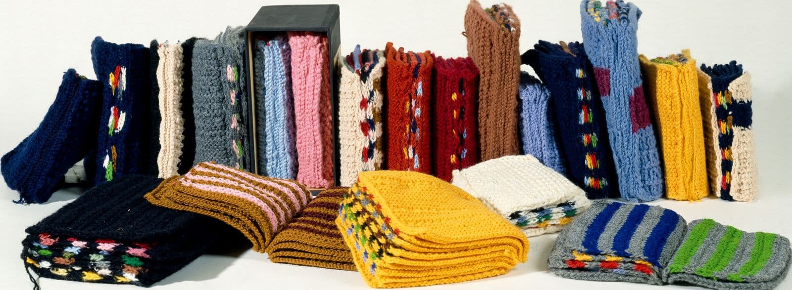 20 multicoloured knitted books in a line