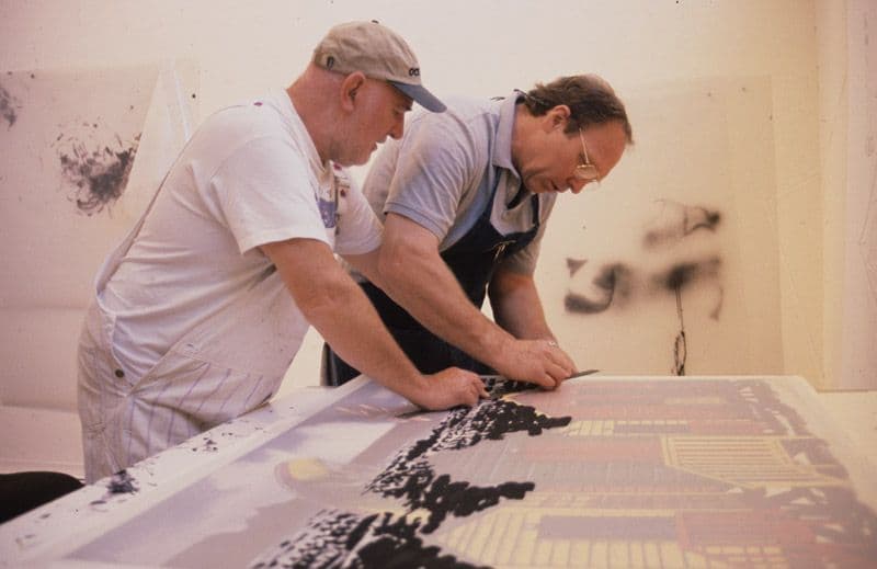 Colour photograph of Malcolm Morley + John Hutcheson, preparing to print lithographic element of 'Beach scene with Parasailor'