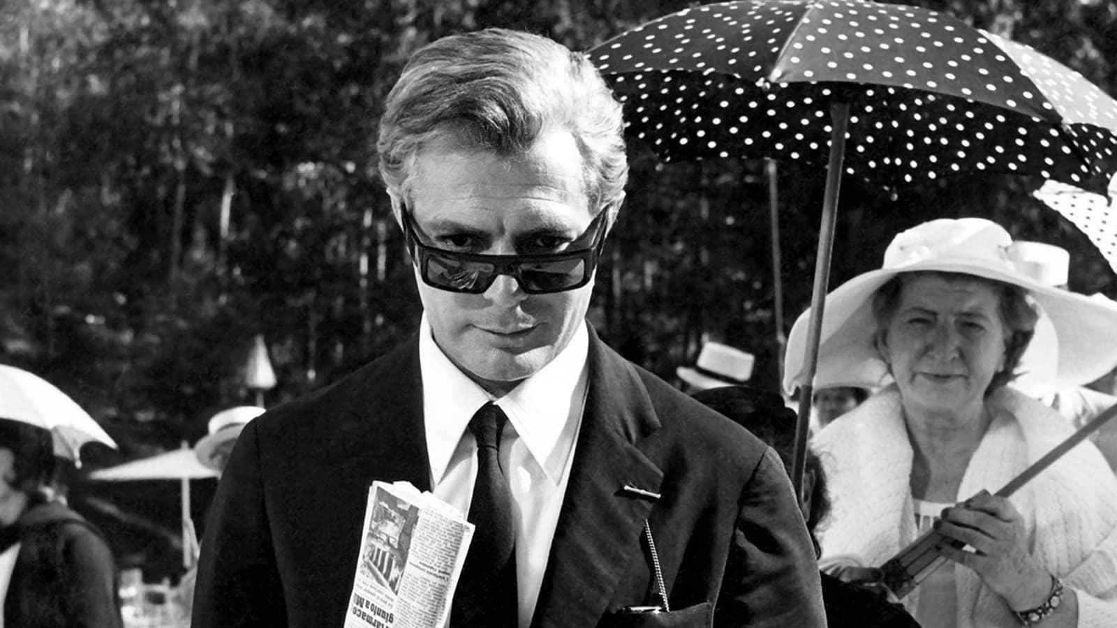 Movie still of a man in a suit wearing sunglasses