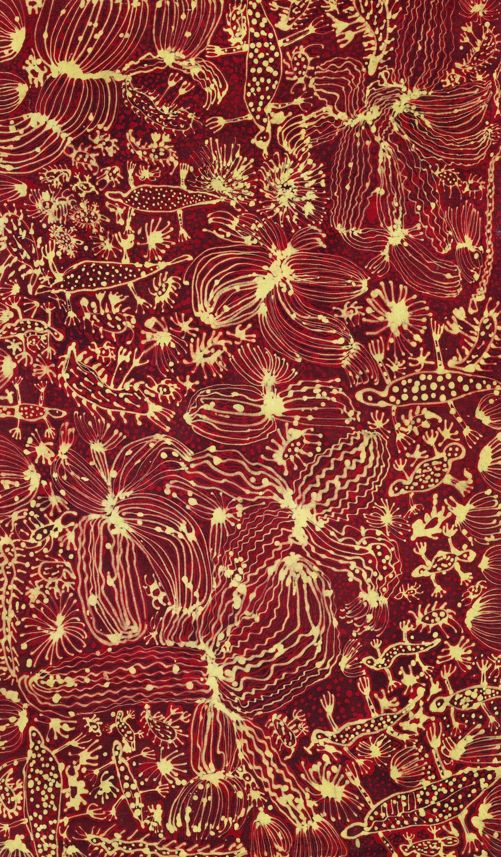 A batik painting in reds and yellows with lines and dots.