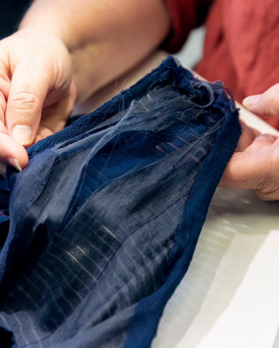 Colour photograph detail of damage to blue Givenchy cocktail dress