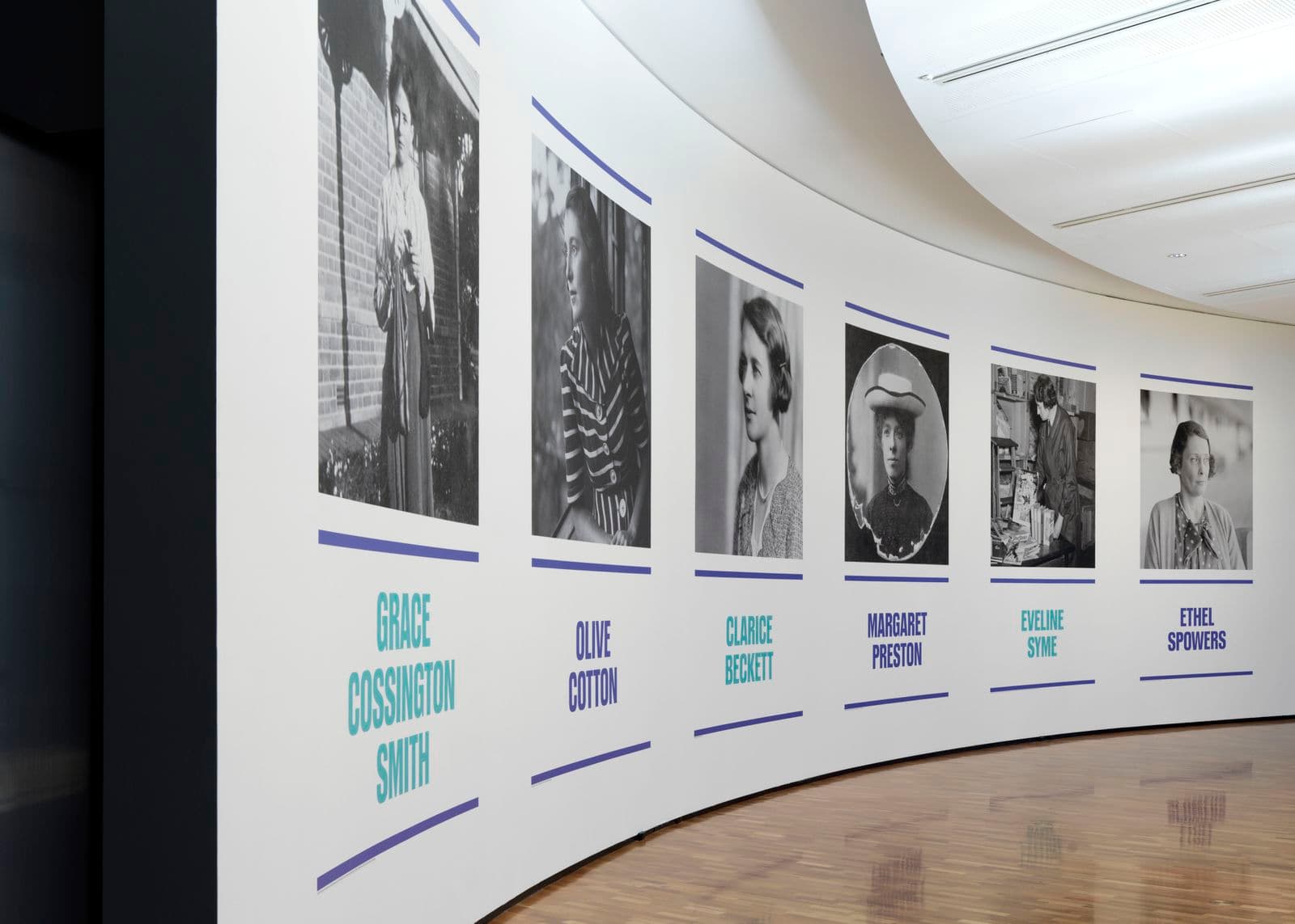 A curved white wall with photographs on it