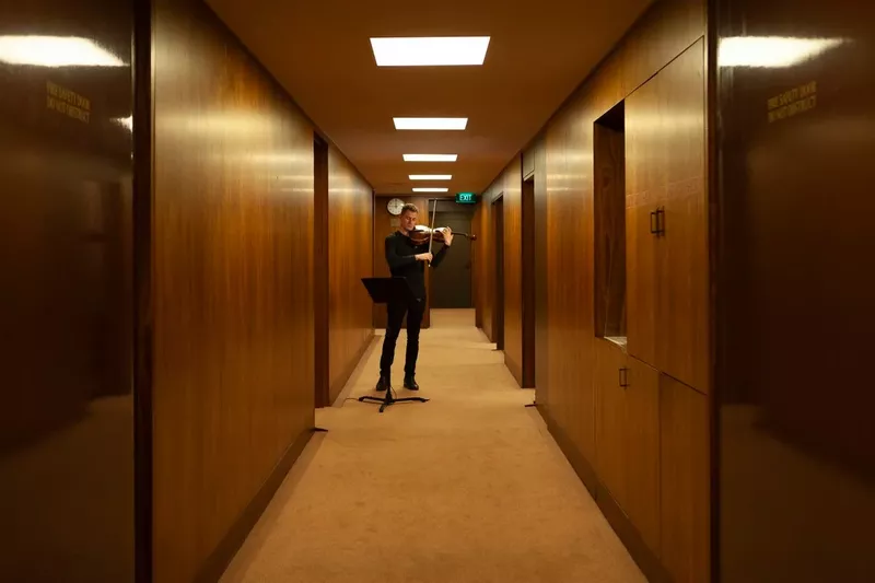 Image of warmly lit hallway with man standing in the centre