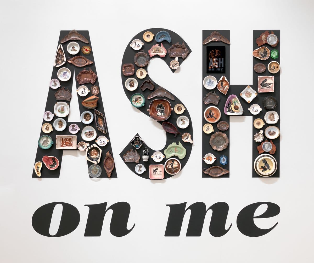The words "Ash on me" with little trinkets stuck on the word "ash"