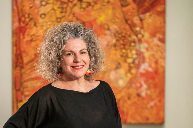 Portrait of a woman standing in front of artwork in an Art Gallery