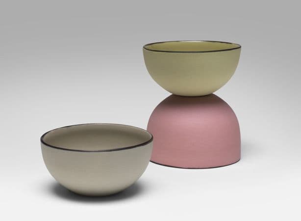 A pastel coloured bowl sits in front of two bowls stacked on top of each other