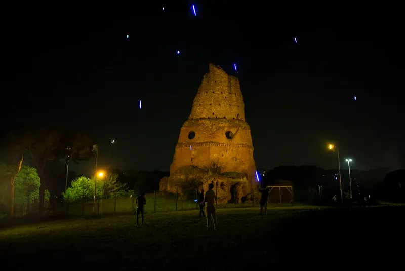 Photo of sandstone ruin at night with neon streaks in the sky