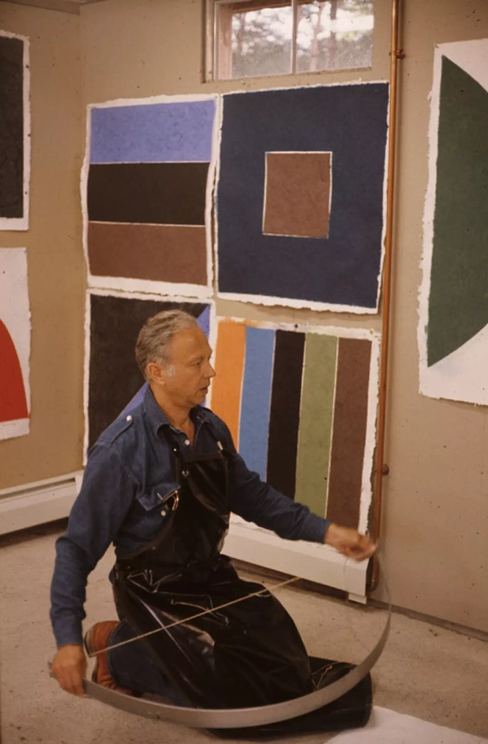 Ellsworth Kelly holding a semicircular mold for use in his ‘Coloured paper image’ series