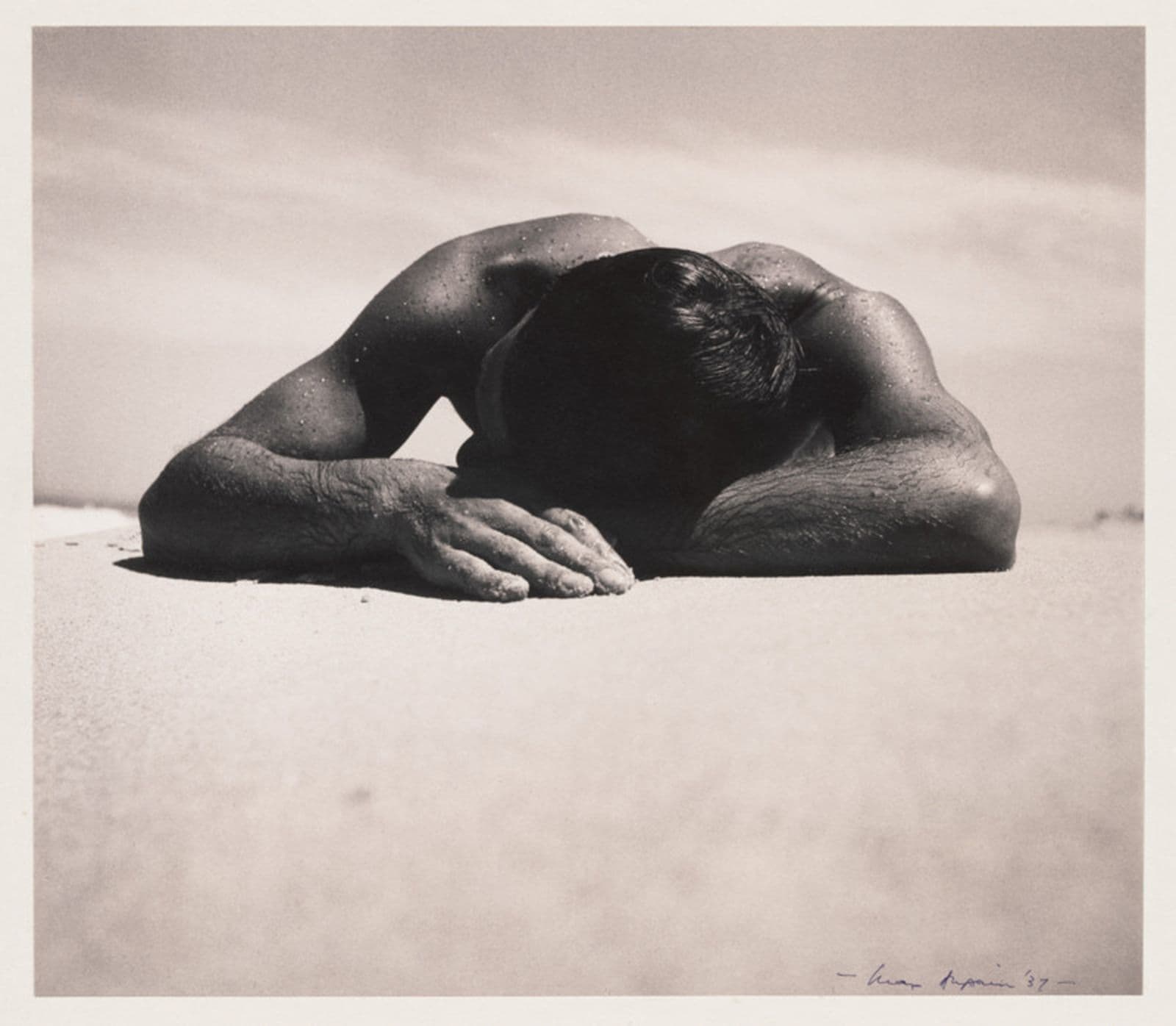 Photo of man lying with his head on his crossed arms