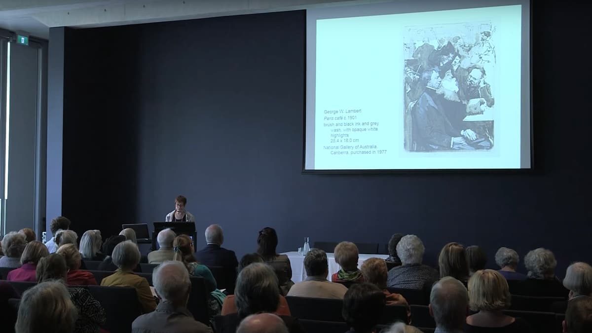 A video still of a woman giving a lecture to a seated audience