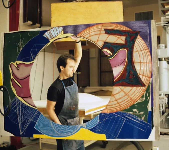 Colour photo of man carrying newly inked magnesium printing element