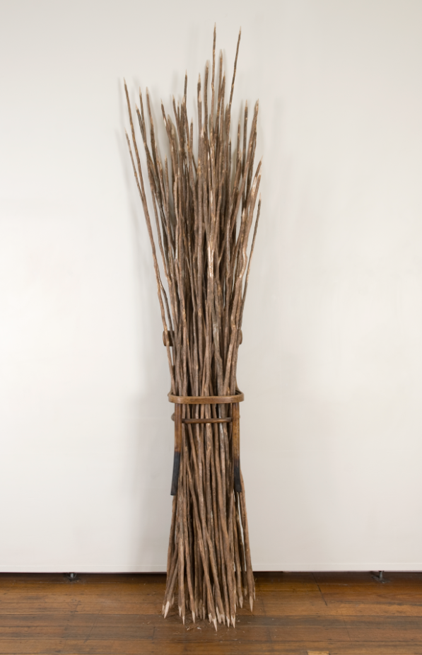 Installation of a bundle of long, sharpened stickd or spears tied together and standing upright