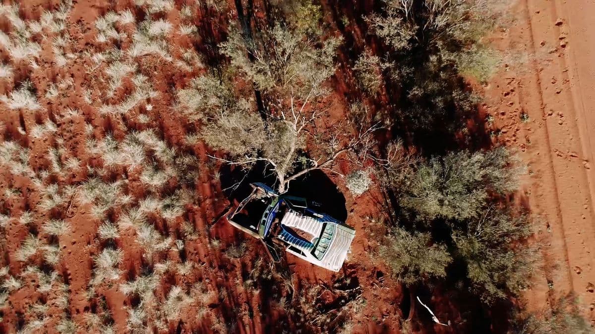 An overhead picture of red desert with a car in the lower left