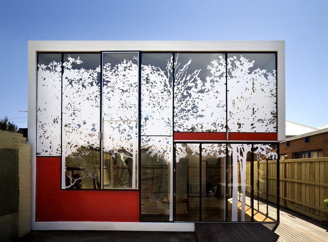 Photograph of glass building with white trees and the red squares drawn on