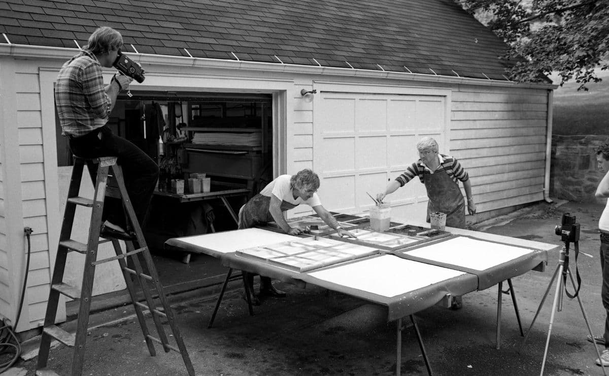 David Hockney and Kenneth Tyler working on the pulp moulds for one of Hockney's six-panel pools from his 'Paper Pools' series with Larry Stanton and Arthur Lambert observing, Tyler Workshop Ltd. driveway next to paper mill, Bedford Village, New York, 1978.