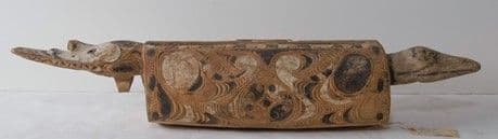 A slit drum carved from wood and decorated with black and white patterns