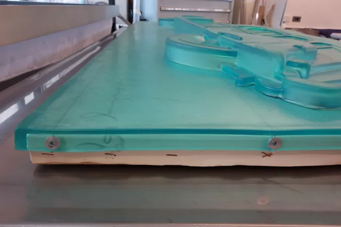 Screws attaching polyurethane relief to wooden strainer with an associated tear