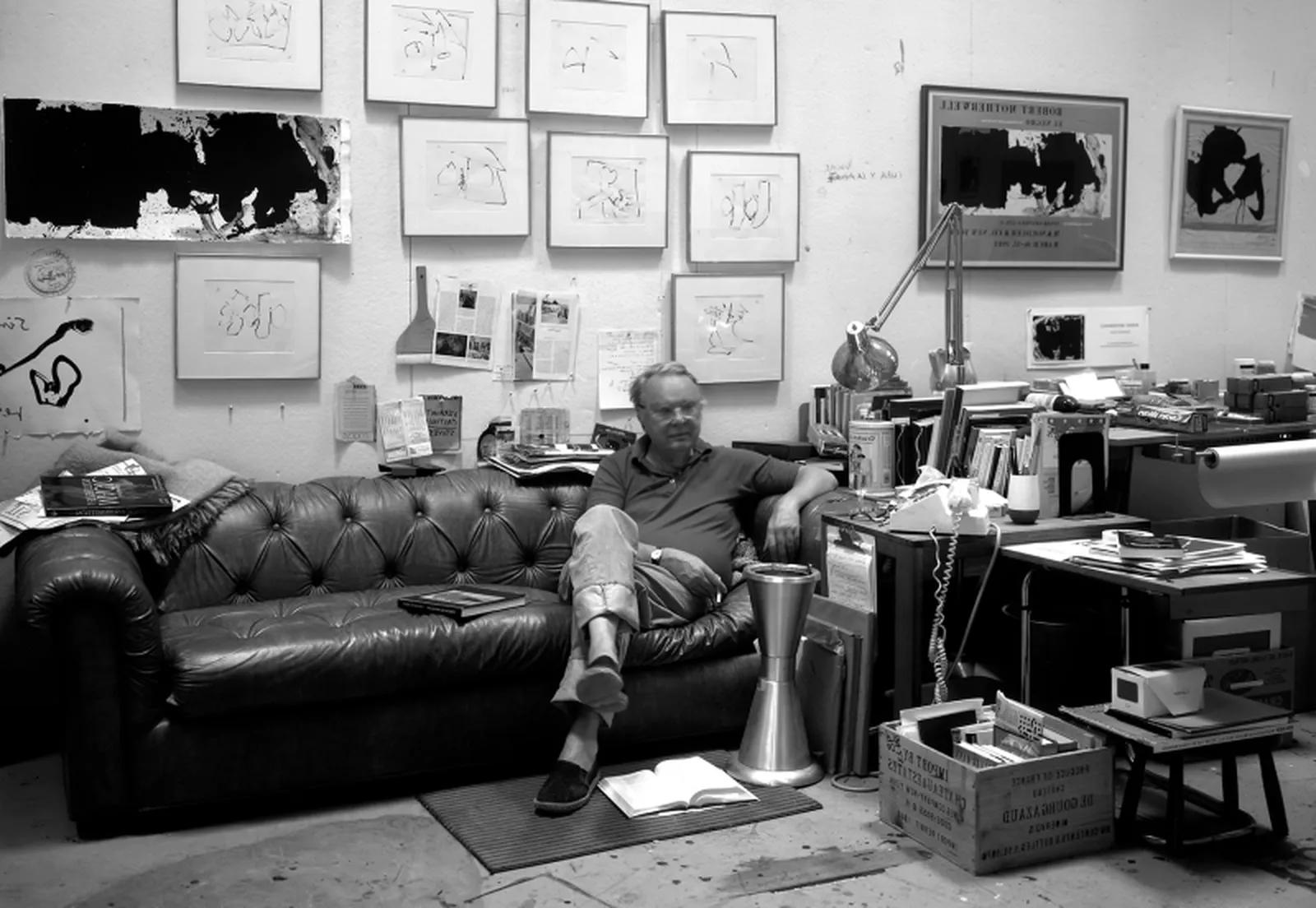Black and white photograph of Robert Motherwell sitting in his studio,