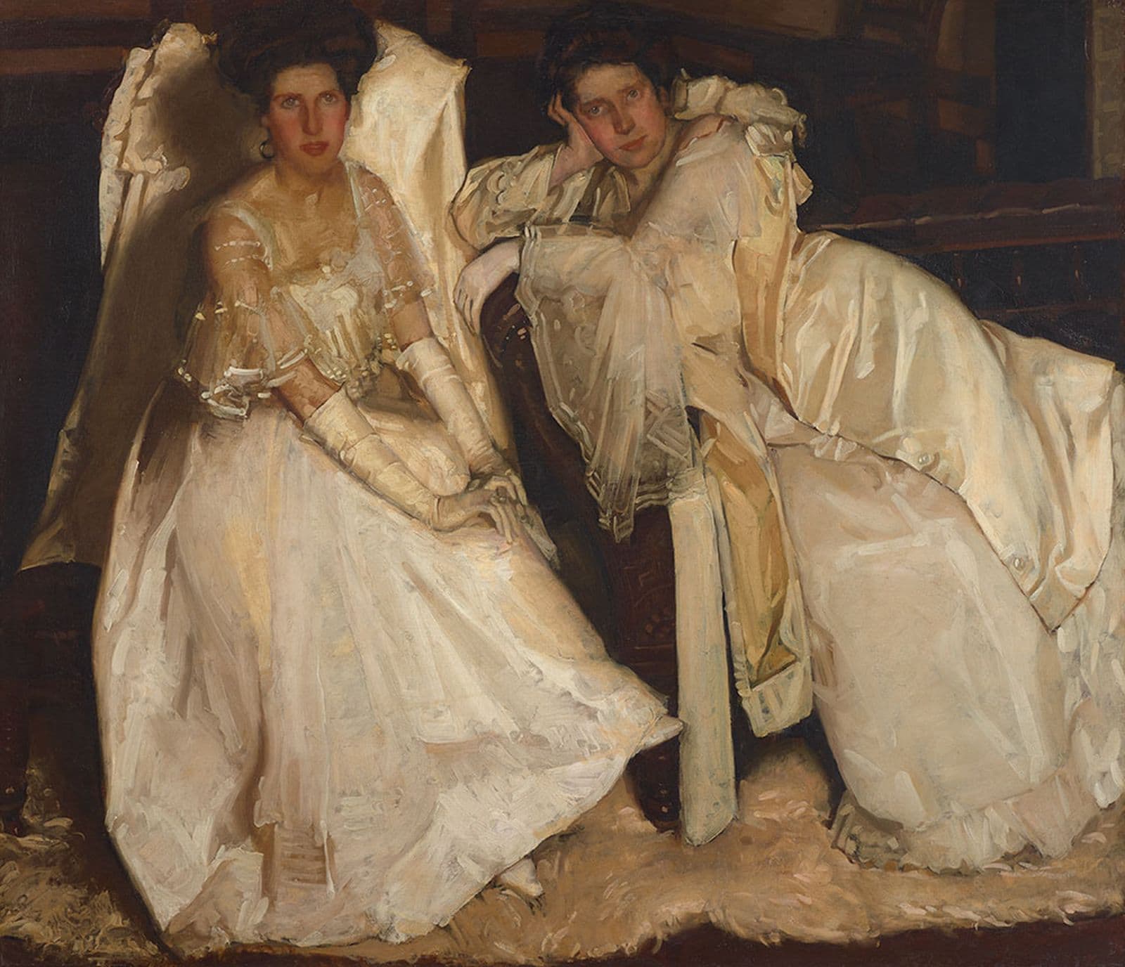Two ladies dressed in white lounge on chairs