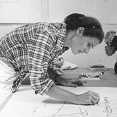 Black and white photograph of Nancy Graves drawing in her studio