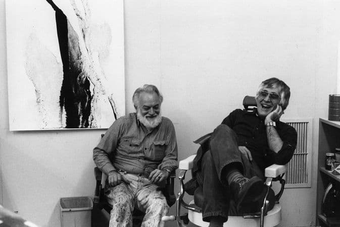 Black and white photograph of Paul Jenkins and Kenneth Tyler in front of a proof from Jenkins' 'Katherine wheel' series