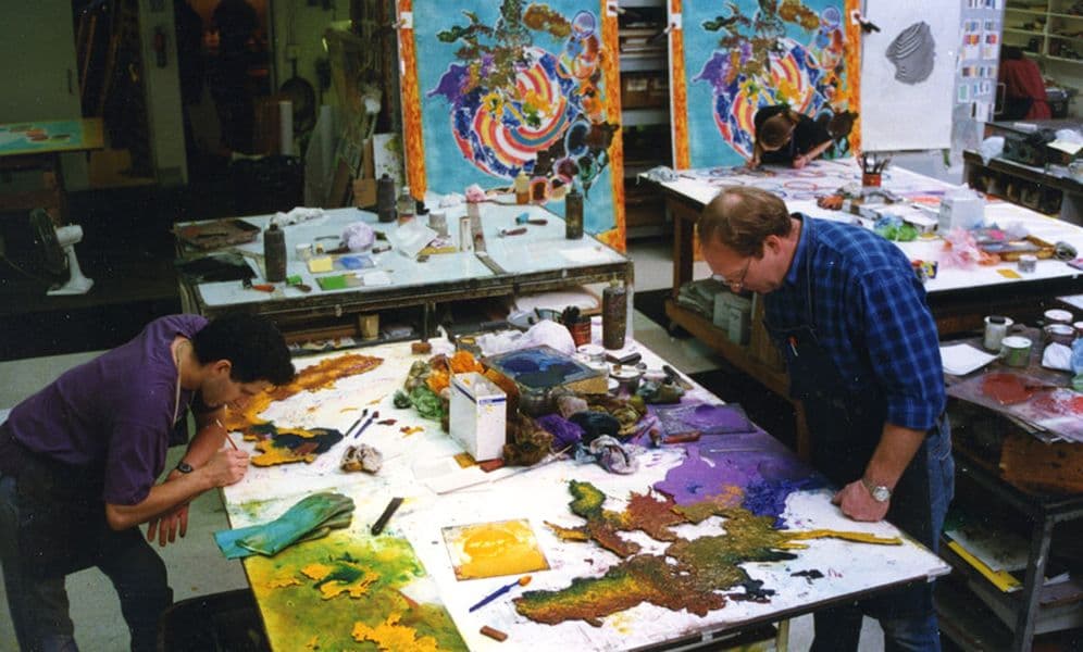Colour photograph of John Hutcheson and Tom Strianese inking cast metal plate elements for Frank Stella's Juam