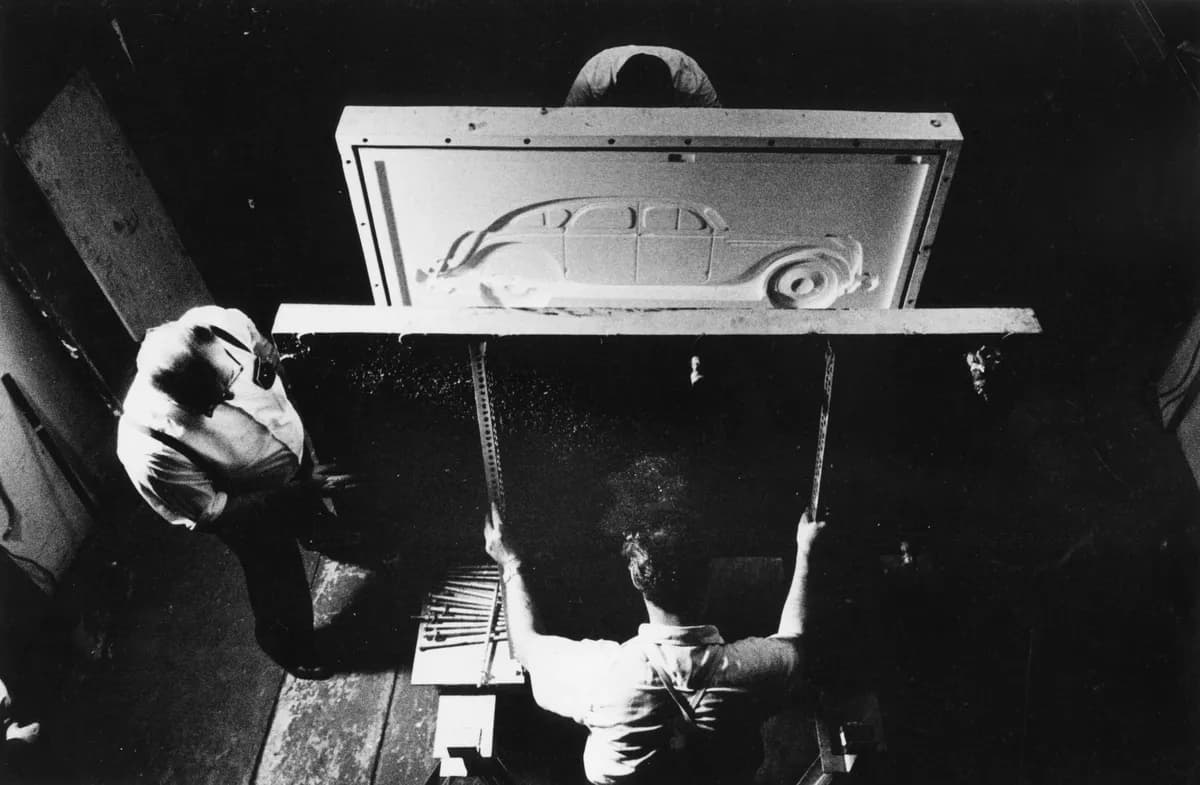 Black and white photograph of workers pressing together the mould for Profile Airflow, 1969