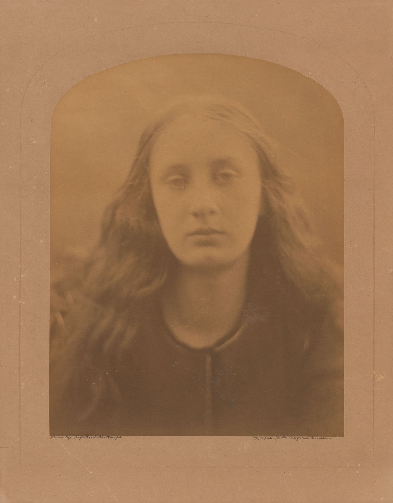 A sepia tone photo of a woman with long hair from 1886