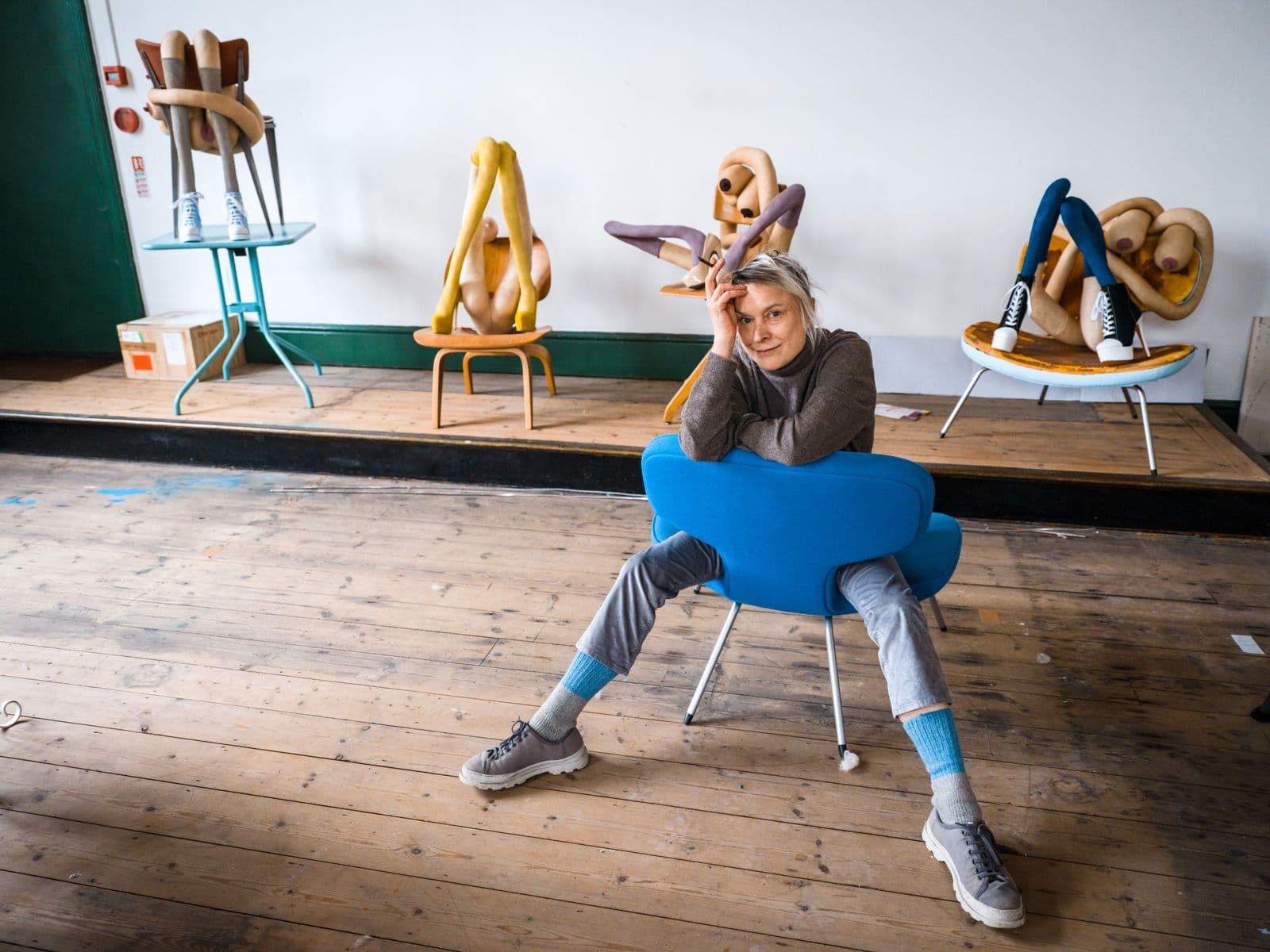 Photograph of Sarah Lucas in front of her sculptures