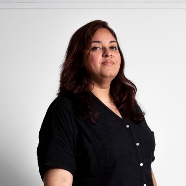 Photographic portrait of a woman standing against a white background.
