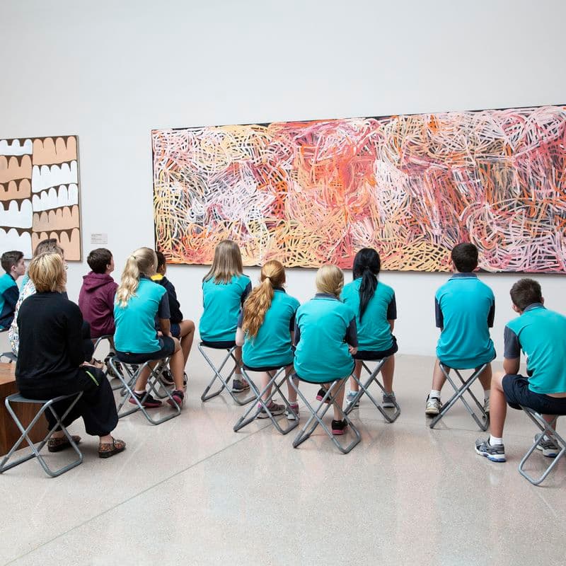 Small group of school children in the first nations galleries viewing Emily Kame Kngwarreye’s Yam awely.